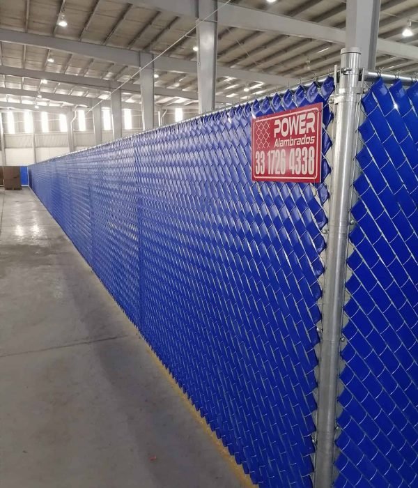 Larga Cerca de malla ciclónica galvanizada con cinta plástica azul dentro de una bodega o nave industrial con placa de Power Alambrados.